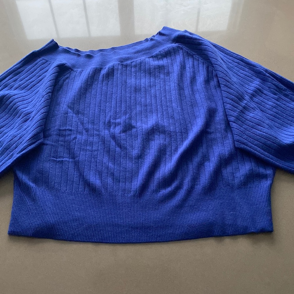 Off-the-shoulder blue sweater with bubble sleeves.